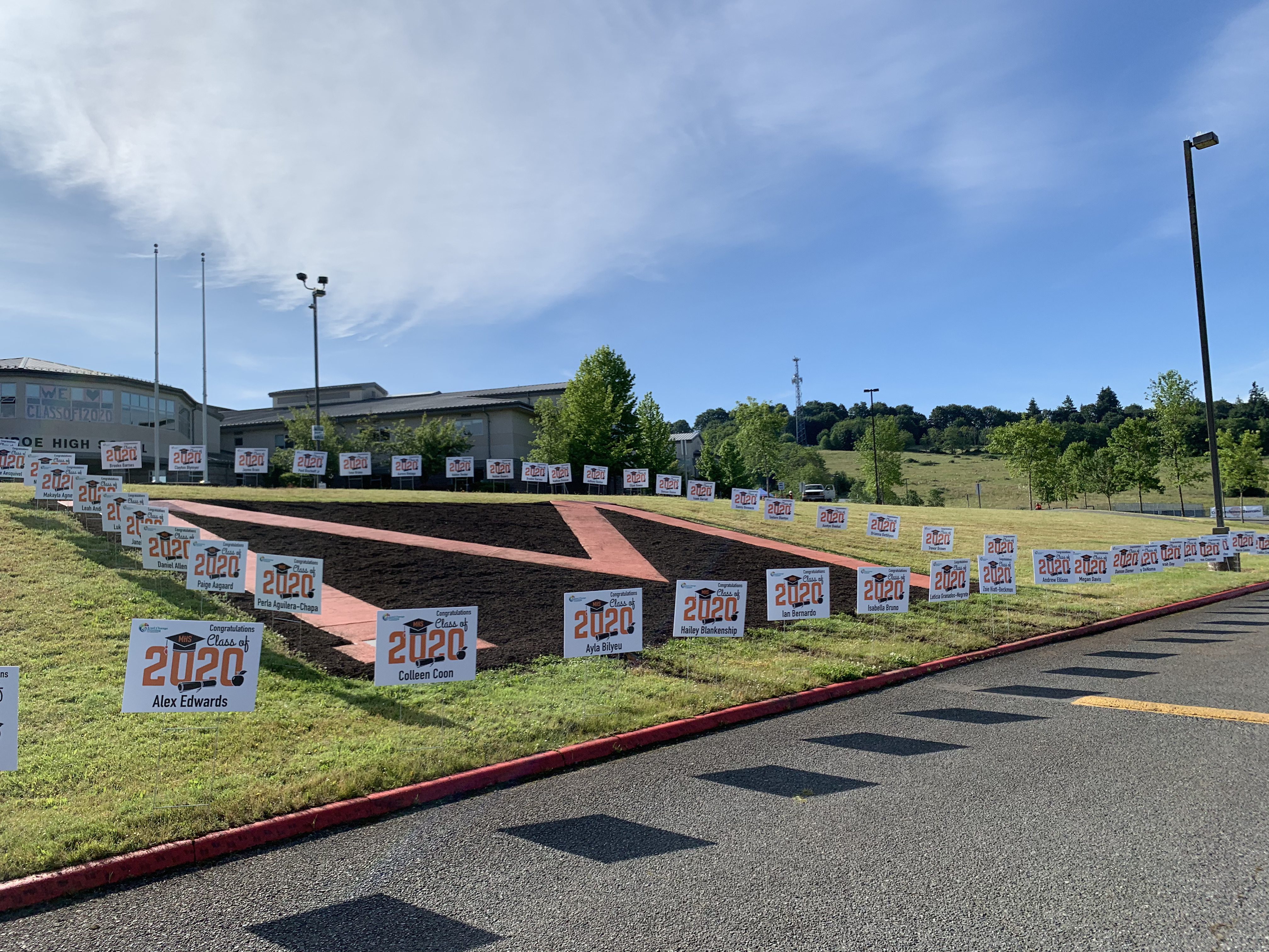Dozens of personalized Class of 2020 yard signs for graduating seniors arranged across the Monroe High School campus.